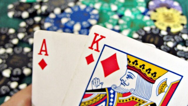A blackjack hand of 21 beside a pile of casino chips; an illustration, not taken at Cowboys Casino.