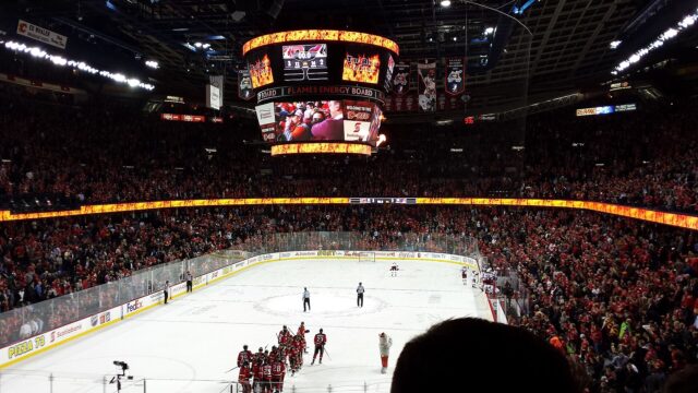 A full crowd in the Saddledome seating bowl as players gather on the ice after an NHL game in April 2015.