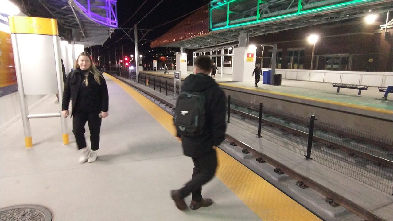 Riders walking along the west platform of the rebuilt Victoria Park/Stampede CTrain station on the evening it opened in December 2023.