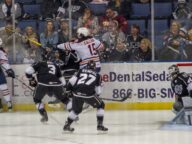 Ontario Reign players battling along the boards in an AHL game on December 31 2018.
