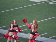Calgary Stampeders cheerleaders with pom-poms on the football field in Calgary, June 2016.